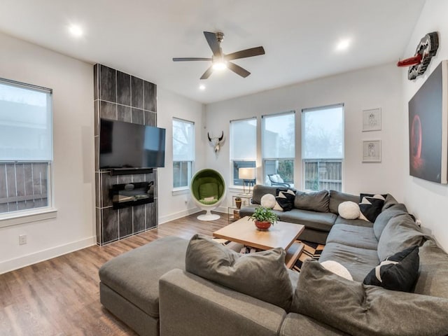 living room featuring ceiling fan, baseboards, wood finished floors, and recessed lighting