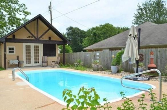 view of pool featuring a fenced in pool, a fenced backyard, an outdoor structure, and a storage structure