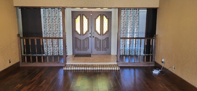 foyer with baseboards and wood finished floors