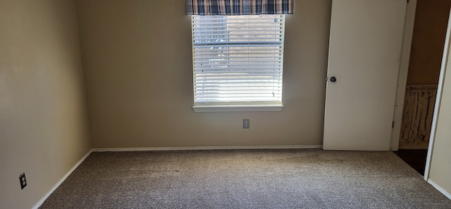 carpeted spare room featuring baseboards