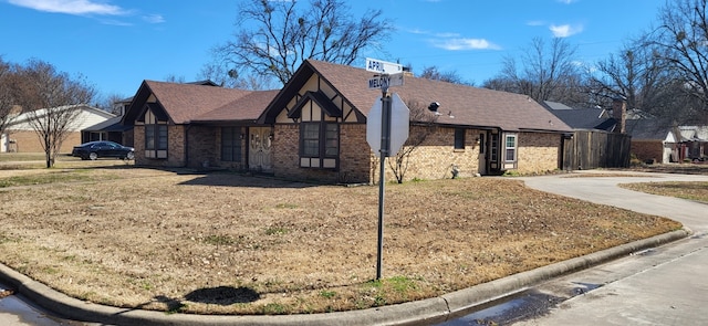 view of front of house with a front yard, concrete driveway, and brick siding