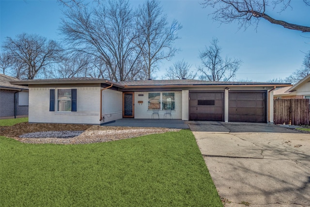 single story home featuring an attached garage, brick siding, fence, driveway, and a front yard