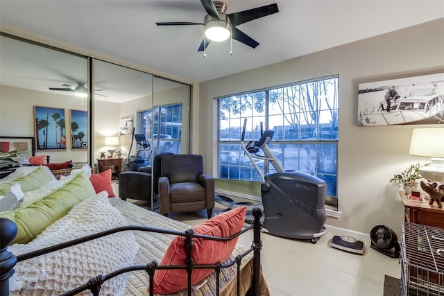 bedroom with a closet, tile patterned flooring, a ceiling fan, and baseboards