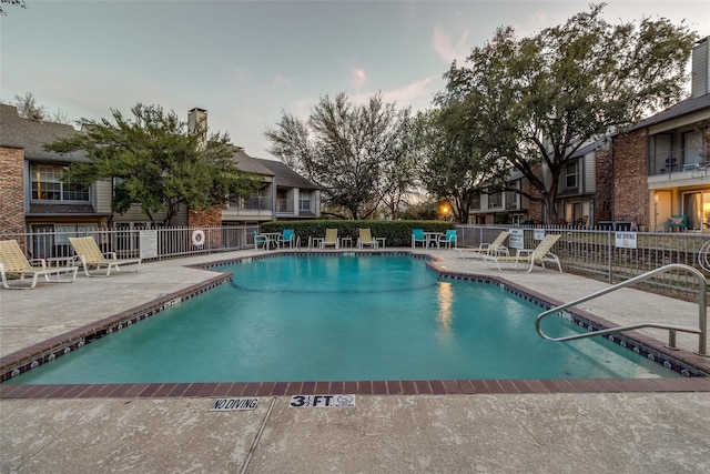 community pool featuring a patio area and fence