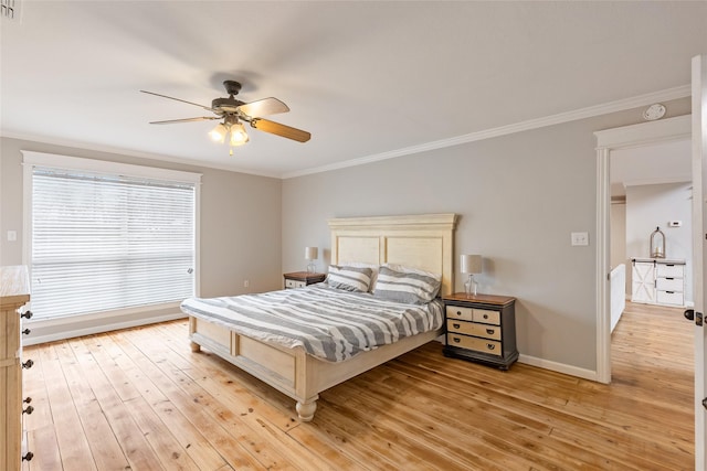 bedroom with ornamental molding, baseboards, and light wood finished floors