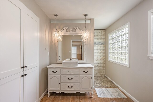 bathroom featuring baseboards, wood finished floors, and vanity