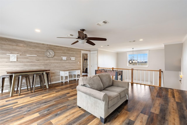 living area with recessed lighting, dark wood finished floors, visible vents, and crown molding