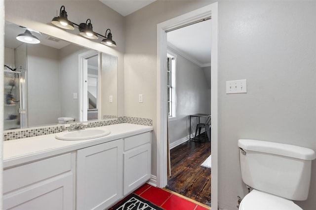 bathroom with toilet, wood finished floors, visible vents, vanity, and ornamental molding