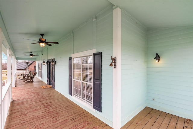 wooden terrace featuring a porch and a ceiling fan