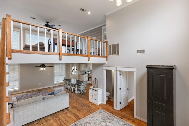 3147 US Highway 67, Sulphur Springs, TX 75482 - living room featuring ceiling fan, baseboards, wood finished floors, ornamental molding, and a high ceiling