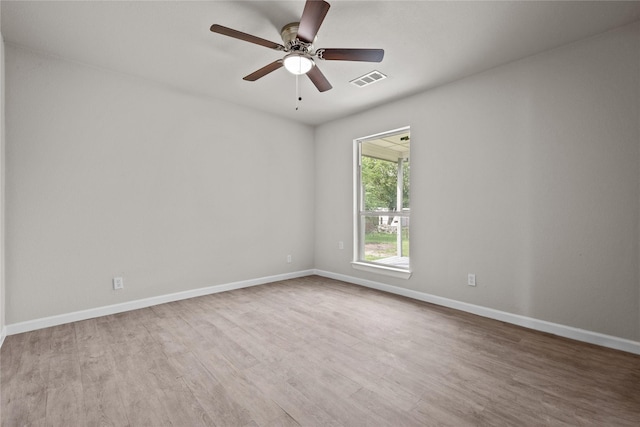 empty room featuring light wood-style floors, visible vents, baseboards, and a ceiling fan