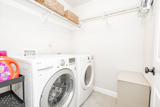 laundry area featuring laundry area, light tile patterned floors, baseboards, and separate washer and dryer