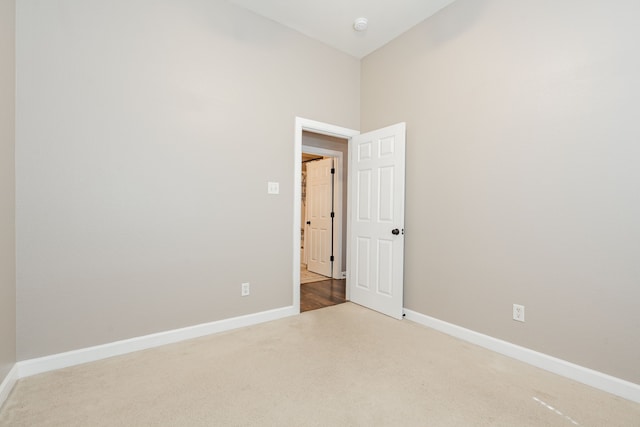 carpeted empty room with baseboards