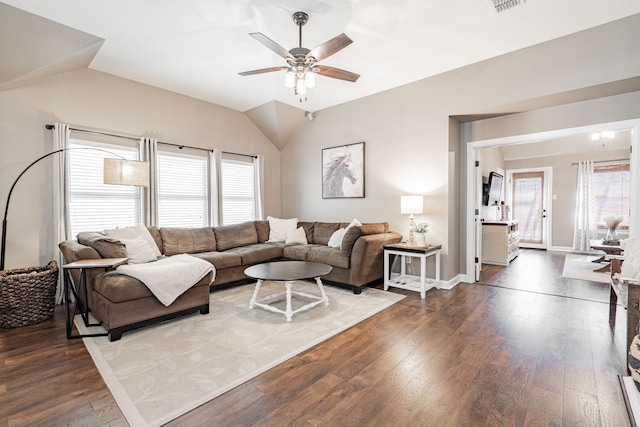 living room with ceiling fan, lofted ceiling, visible vents, baseboards, and dark wood-style floors