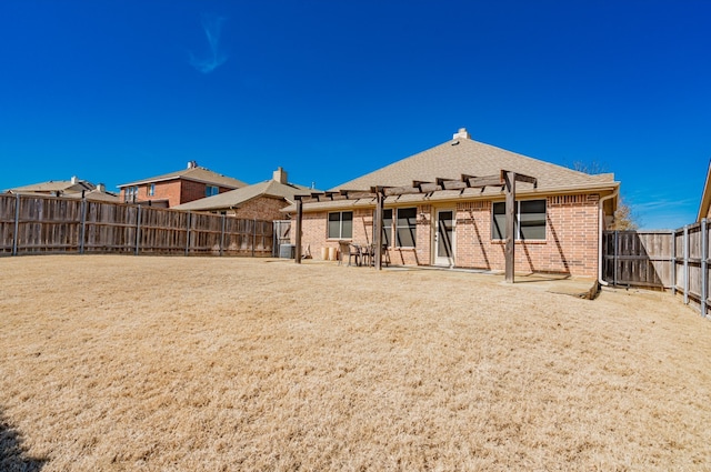 back of house with a fenced backyard, roof with shingles, a patio area, a pergola, and brick siding