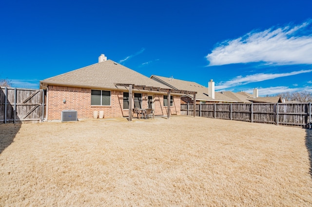 back of property featuring a fenced backyard, cooling unit, brick siding, a shingled roof, and a chimney