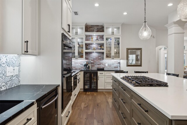 kitchen featuring gray cabinets, a ceiling fan, a stone fireplace, stainless steel appliances, and white cabinetry