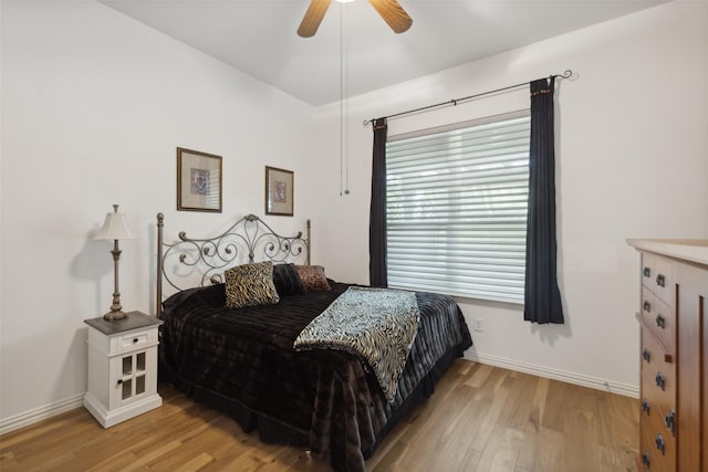 bedroom with baseboards, ceiling fan, and light wood finished floors
