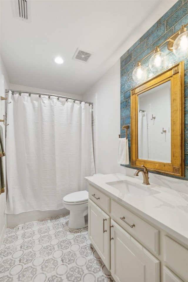 bathroom featuring vanity, shower / bathtub combination with curtain, toilet, and visible vents