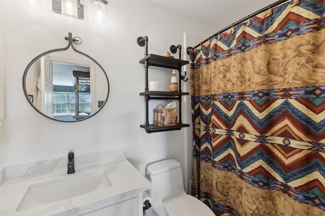 bathroom featuring vanity, toilet, and curtained shower