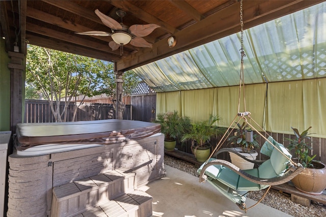 view of patio / terrace with a fenced backyard, ceiling fan, and a hot tub