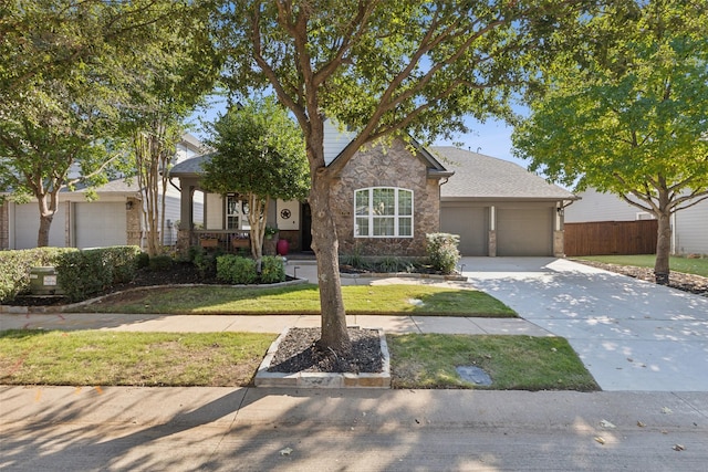 view of front of home with fence, an attached garage, driveway, and a front lawn