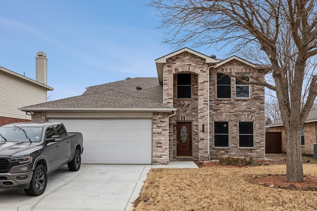 traditional-style house featuring an attached garage, driveway, roof with shingles, and brick siding