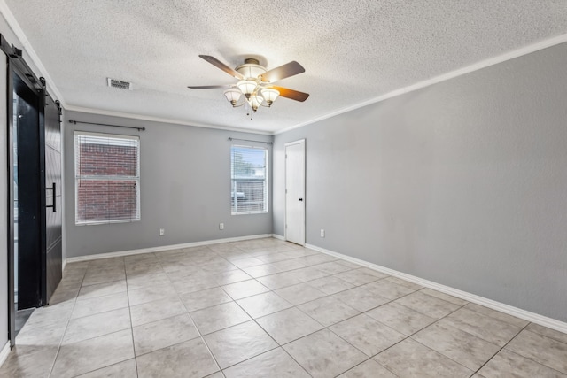 unfurnished room with a barn door, light tile patterned flooring, visible vents, a ceiling fan, and ornamental molding