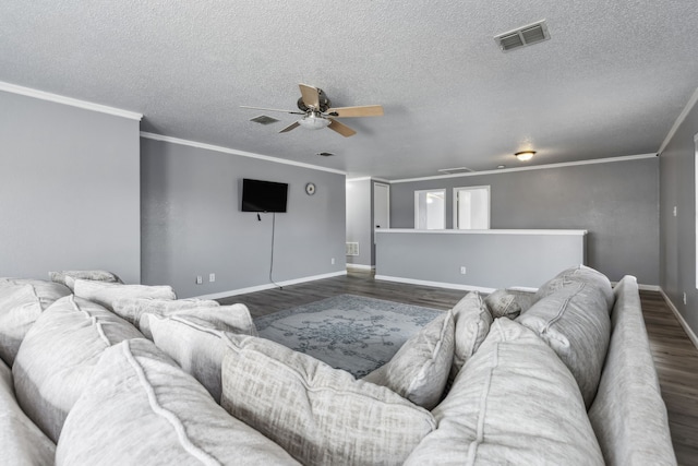 living area with dark wood-style floors, ornamental molding, and visible vents