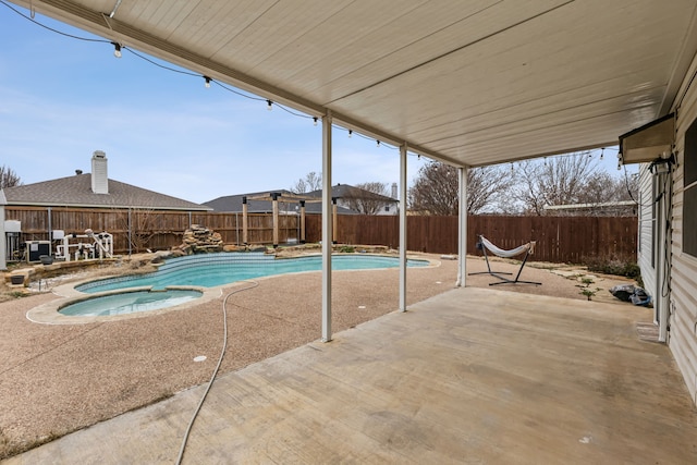 view of swimming pool with a patio area, a fenced backyard, and a pool with connected hot tub