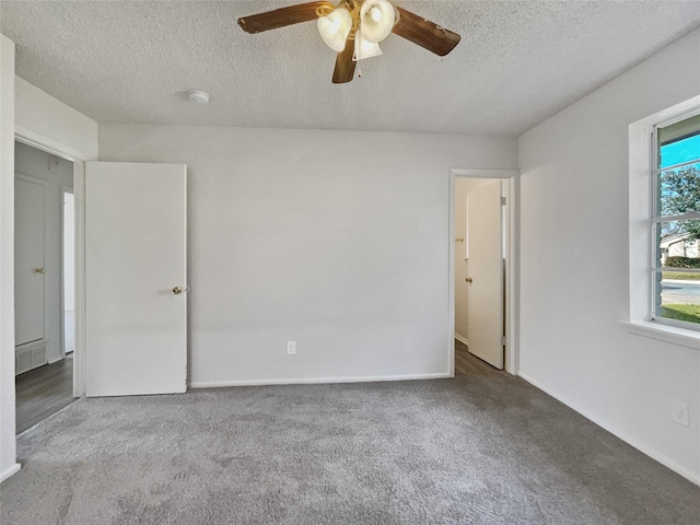 spare room featuring a textured ceiling, ceiling fan, and light colored carpet