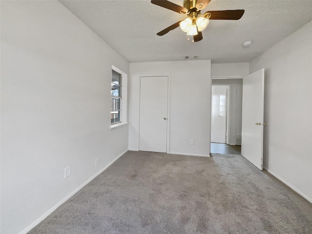 unfurnished bedroom with light carpet, multiple windows, a textured ceiling, and visible vents