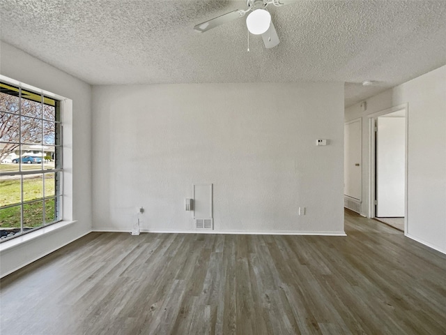 unfurnished room with baseboards, visible vents, a ceiling fan, wood finished floors, and a textured ceiling