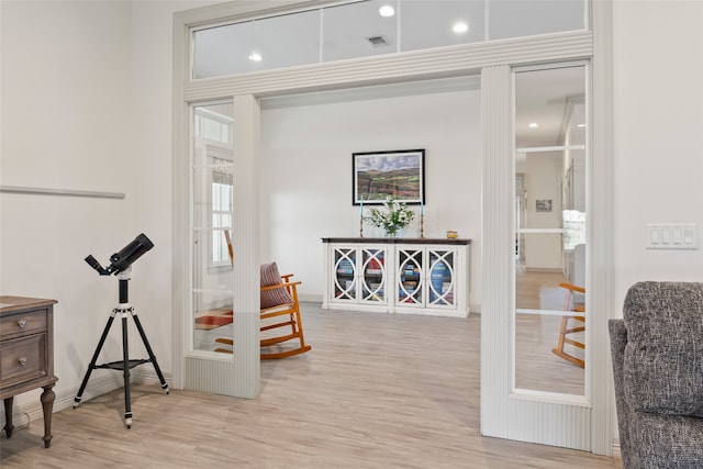 sitting room featuring light wood-type flooring and visible vents