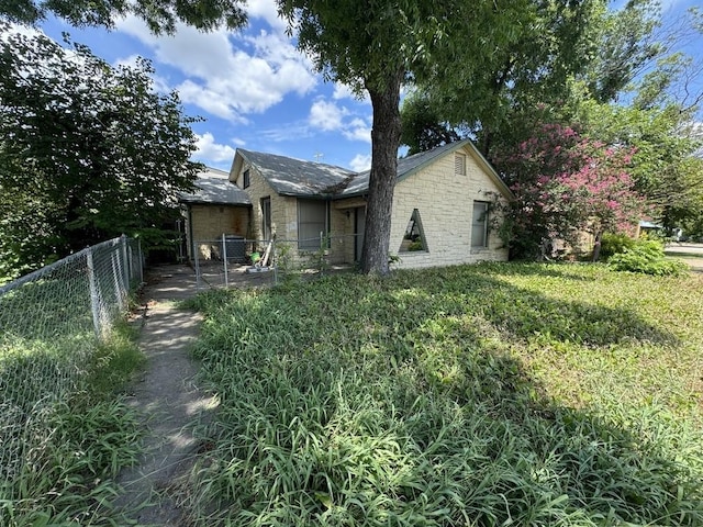 view of side of home with fence and a yard