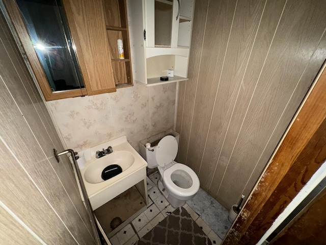 half bath featuring toilet, a sink, and tile patterned floors