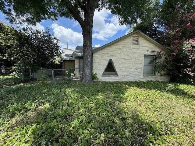 rear view of property with fence and a lawn