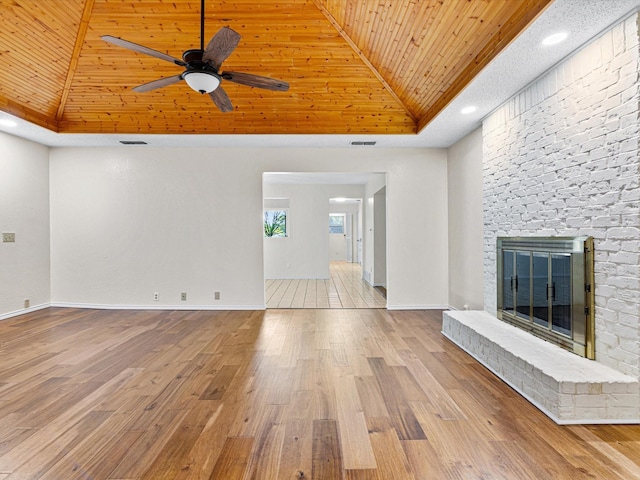 unfurnished living room with a large fireplace, visible vents, wood finished floors, and wood ceiling