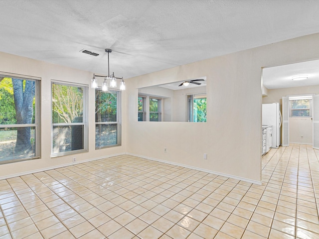 unfurnished room with light tile patterned floors, baseboards, visible vents, and a textured ceiling