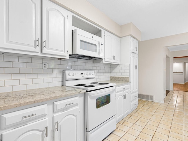 kitchen featuring white appliances, visible vents, and white cabinets