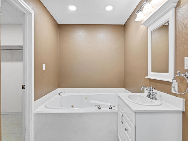 bathroom featuring recessed lighting, tile patterned flooring, a jetted tub, and vanity