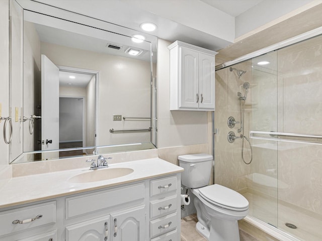 bathroom featuring toilet, a stall shower, visible vents, and vanity