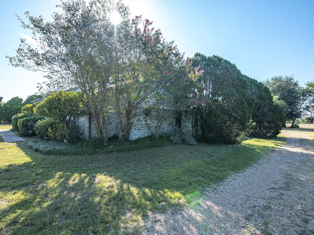 view of property exterior featuring driveway, a mountain view, and a yard