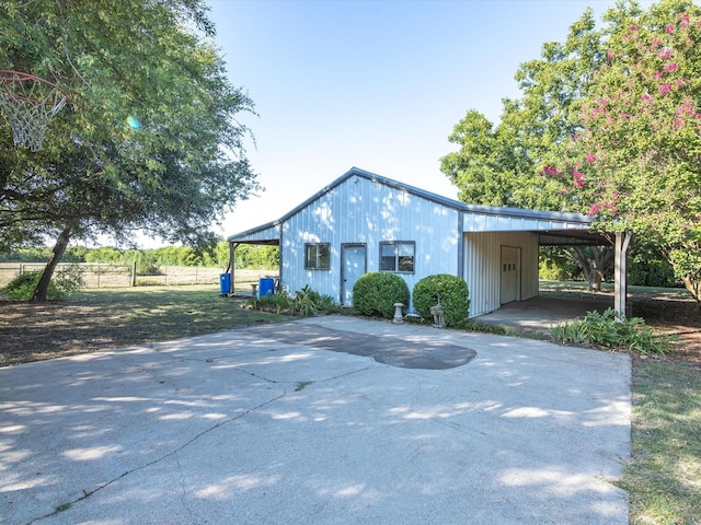 view of front of home featuring an attached carport, driveway, and fence