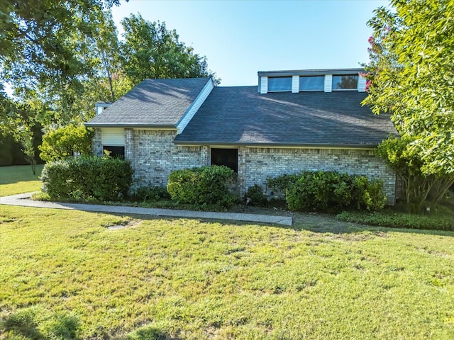 view of front facade with a front lawn and brick siding