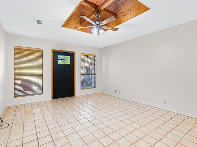 foyer entrance featuring light tile patterned floors, baseboards, visible vents, a ceiling fan, and a tray ceiling