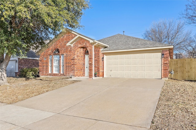 view of front of home with driveway, an attached garage, a shingled roof, and brick siding