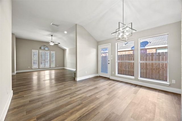 interior space with visible vents, vaulted ceiling, wood finished floors, and ceiling fan with notable chandelier