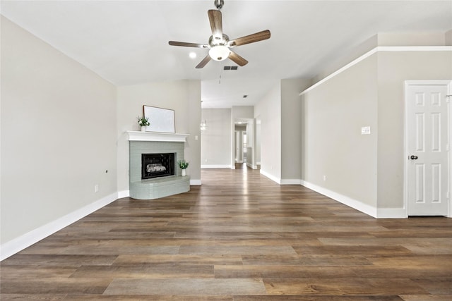 unfurnished living room with baseboards, visible vents, a ceiling fan, dark wood-style flooring, and a fireplace