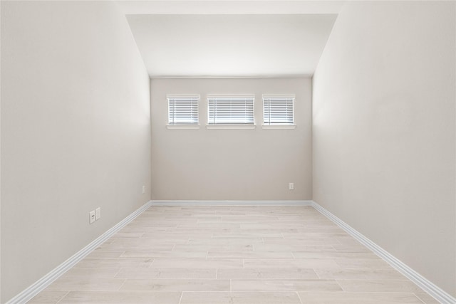 empty room featuring light wood finished floors and baseboards